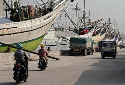Pengendara melintasi kapal yang bersandar di Pelabuhan Sunda Kelapa, Jakart Utara, Jumat (21/5/2021).