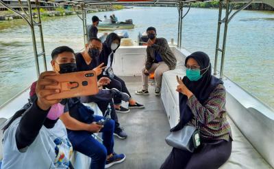 Pengunjung menikmati suasana santai saat berwisata menggunakan perahu Bukit Baruga menyusuri Sungai Tello, Makassar, Sulawesi Selatan, Sabtu (22/5/2021).