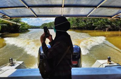Pengunjung menikmati suasana santai saat berwisata menggunakan perahu Bukit Baruga menyusuri Sungai Tello, Makassar, Sulawesi Selatan, Sabtu (22/5/2021).