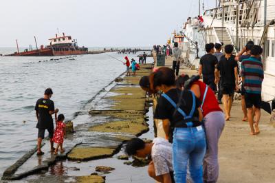 Warga menikmati liburan akhir pekan di Dermaga Muara Angke, Jakarta Utara, Minggu (23/5/2021).