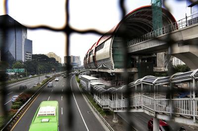 Kendaraan melintasi proyek Light Rail Transit (LRT) Jabodebek di Jalan MT Haryono, Jakarta, Minggu (23/5/2021).