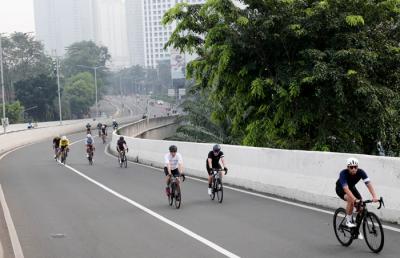Pesepeda melintasi Jalan Layang Non-Tol (JLNT) Kampung Melayu-Tanah Abang, Jakarta, Minggu (23/5/2021).