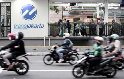 Calon penumpang menunggu bus Transjakarta di halte Bundaran HI, Jakarta, Senin (24/5/2021).