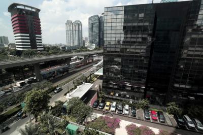 Pekerja berjalan di jalur Light Rail Transit di kawasan Jalan Rasuna Said, Jakarta, Kamis (27/5/2021).
