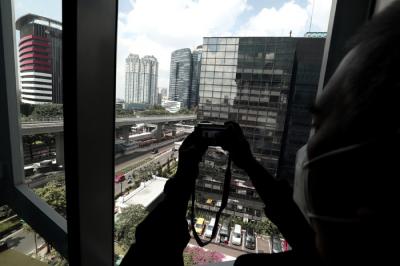 Pekerja berjalan di jalur Light Rail Transit di kawasan Jalan Rasuna Said, Jakarta, Kamis (27/5/2021).