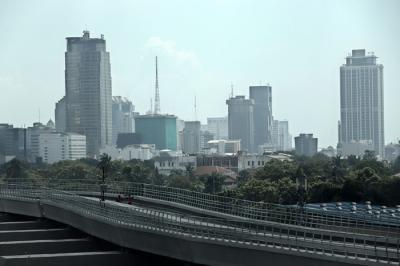 Pekerja berjalan di jalur Light Rail Transit di kawasan Jalan Rasuna Said, Jakarta, Kamis (27/5/2021).