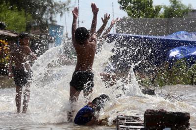 Sejumlah anak bermain dibibir pantai ketika banjir rob menerjang kawasan wisata Kenjeran Park Surabaya, Jawa Timur, Jumat (28/5/2021).