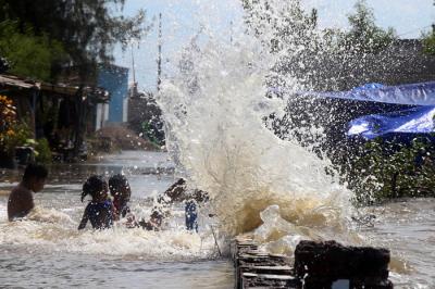 Sejumlah anak bermain dibibir pantai ketika banjir rob menerjang kawasan wisata Kenjeran Park Surabaya, Jawa Timur, Jumat (28/5/2021).