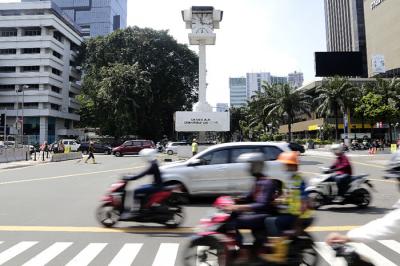 Kendaraan melintas di dekat Menara Jam Thamrin, Jakarta Pusat, Minggu (30/5/2021).