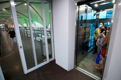 Penumpang Transjakarta saat menggunakan lift di JPO Jembatan Gantung, Daan Mogot, Jakarta Barat, Sabtu (29/5/2021).