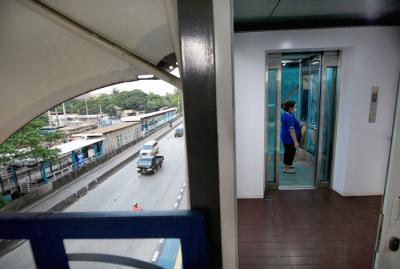 Penumpang Transjakarta saat menggunakan lift di JPO Jembatan Gantung, Daan Mogot, Jakarta Barat, Sabtu (29/5/2021).