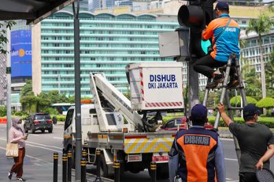 Petugas memperbaiki lampu lalu lintas di penyebrangan orang di Bundaran HI, Jakarta Pusat, Minggu (30/5/2021).