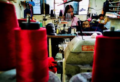 Pekerja menyelesaikan produksi pakaian jadi di salah satu konveksi di kawasan Jakarta Barat, Senin (31/5/2021).