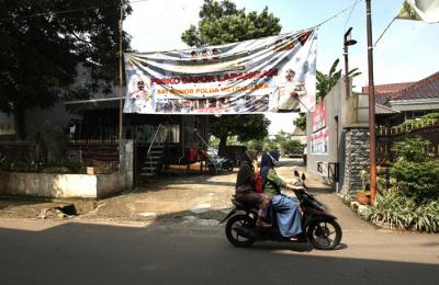 Warga melintas di Jalan Darusalam di kawasan RT 03 RW 03 Cilangkap, Cipayung, Jakarta Timur, Kamis (3/6/2021).