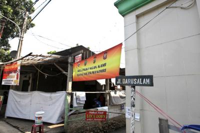 Warga melintas di Jalan Darusalam di kawasan RT 03 RW 03 Cilangkap, Cipayung, Jakarta Timur, Kamis (3/6/2021).