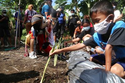 Punakawan yang diperankan oleh pendongeng Kak Harris mengajak anak-anak menanam sayuran di sepadan sungai Kalibokor Surabaya, Jawa Timur, Kamis (3/6/2021).