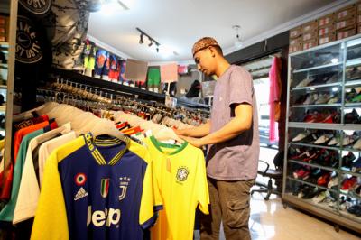 Pengunjung memilih jersey tim jagoannya asal Eropa di sebuah toko peralatan olahraga, kawasan Kebon Pala, Makasar, Jakarta Timur, Kamis (3/6/2021).