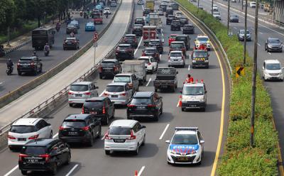 Petugas kembali membuka jalur yang dipakai untuk sistem contraflow di Jalan Jenderal Gatot Subroto, Jakarta, Jumat (4/6/2021).