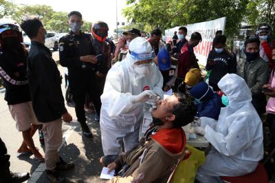 Petugas melakukan tes swab massal bagi pengendara yang hendak masuk Kota Pahlawan di pos penyekatan Polres Pelabuhan Tanjung Perak Surabaya, Minggu (6/6/2021).