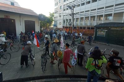 Pesepeda dengan memakai pakaian tradisional memeriksa sepeda antiknya dalam kegiatan Parade Sepeda Penny di Kawasan Kota Lama Semarang, Minggu (6/6/2021).