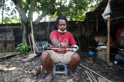 Wawan menyiapkan bambu untuk dijadikan bahan pembuatan kerangka ondel-ondel di kawasan Perkampungan Budaya Betawi Setu Babakan, Jagakarsa, Minggu (6/6/2021).