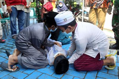 Peserta bersembunyi dibawah meja ketika mengikuti simulasi bencana alam di Koramil Tipe A 0831/04 Sukolilo Surabaya, Jawa Timur, Minggu (6/6/2021).