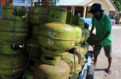 Pekerja harian lepas menurunkan gas elpji 3 kg di Pelabuhan Dermaga Pulau Panggang Provinsi DKI Jakarta, Senin (7/6/2021).