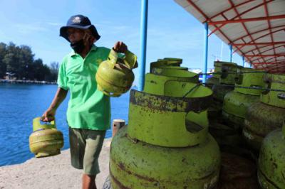 Pekerja harian lepas menurunkan gas elpji 3 kg di Pelabuhan Dermaga Pulau Panggang Provinsi DKI Jakarta, Senin (7/6/2021).