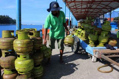 Pekerja harian lepas menurunkan gas elpji 3 kg di Pelabuhan Dermaga Pulau Panggang Provinsi DKI Jakarta, Senin (7/6/2021).