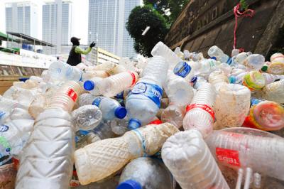 Petugas mengangkut sampah botol plastik dari kali Ciliwung, Jakarta Pusat, Kamis (10/6/2021).