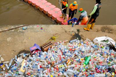 Petugas mengangkut sampah botol plastik dari kali Ciliwung, Jakarta Pusat, Kamis (10/6/2021).
