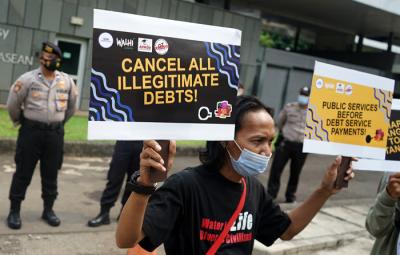 Aktivis Walhi menunjukkan poster saat menggelar aksi unjuk rasa di depan Kedubes Inggris, Kuningan, Jakarta, Jumat (11/6/2021).