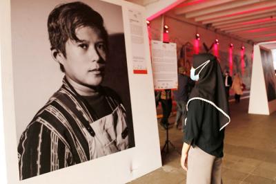 Pejalan kaki melintas di dekat pameran foto Jakpreneur Fest di Terowongan Kendal, Jakarta, Jumat (11/6/2021).