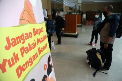 Pekerja Migran Indonesia (PMI) menjalani tes Swab PCR saat tiba di Asrama Haji Sukolilo Surabaya, Jumat (11/6/2021).