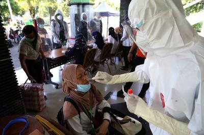 Pekerja Migran Indonesia (PMI) menjalani tes Swab PCR saat tiba di Asrama Haji Sukolilo Surabaya, Jumat (11/6/2021).
