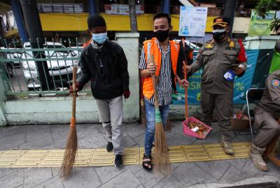 Warga terjaring razia masker yang diadakan petugas Satpol PP di kawasan Tanjung Duren, Jakarta, Jumat (11/6/2021).