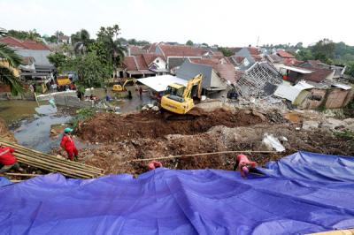Petugas memasang terpal untuk menutupi tanah longsor di Perumahan Nerada Estate Ciputat, Tangerang Selatan, Banten, Sabtu (12/6/2021).