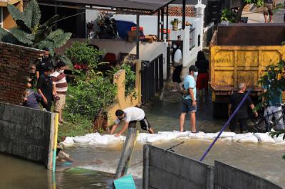 Warga memantau arus air yang masuk dan menyebabkan banjir di perumahannya di Perumahan Nerada Estate Ciputat, Tangerang Selatan, Banten, Sabtu (12/6/2021).