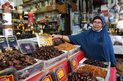 Pedagang menunggu pembeli di gerai oleh-oleh Haji dan Umroh di kawasan Pasar Tanah Abang, Jakarta, Minggu (13/6/2021).