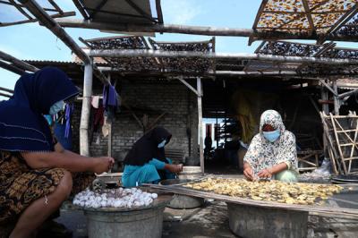 Perajin mengolah ikan terung laut untuk dijadikan kerupuk terung di Pesisir Kenjeran Surabaya, Jawa Timur, Selasa (15/6/2021).