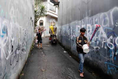 Kelompok pengarak Ondel-ondel tampak keluar dari pemukiman padat di kawasan Kramat Pulo, Jakarta Pusat.
