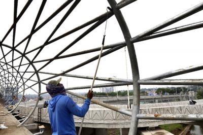 Sejumlah pekerja menyelesaikan proyek pembangunan jembatan penyeberangan orang di Jalan Raya Lenteng Agung, Jagakarsa, Jakarta Selatan, Kamis, (17/6/2021).
