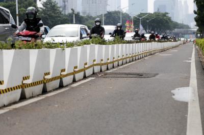 Pesepeda melintasi jalur sepeda permanen di kawasan Jalan Sudirman, Jakarta Pusat, Jumat (18/6/2021).