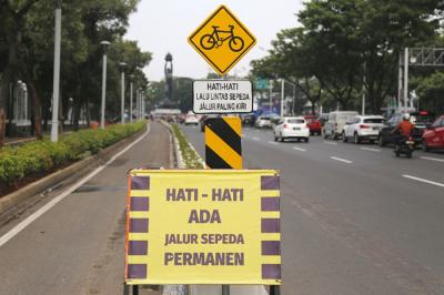 Pesepeda melintasi jalur sepeda permanen di kawasan Jalan Sudirman, Jakarta Pusat, Jumat (18/6/2021).