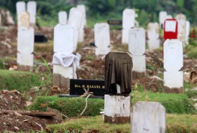 Sebuah papan nisan diberi kain penanda di TPU Srengseng Sawah, Jakarta Selatan, Jumat (18/6/2021).