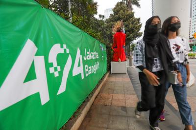 Pengunjung saat berfoto didepan ondel-ondel yang terpajang di kawasan Jalan Jenderal Sudirman, Jakarta Pusat, Minggu (20/6/2021).