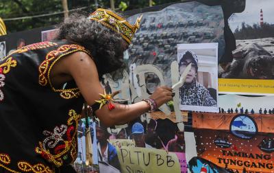 Demonstran melakukan aksi teatrikal menolak revisi UU Minerba di kawasan Bundaran Patung Kuda Arjuna Wijaya, Jakarta, Senin (21/6/2021).
