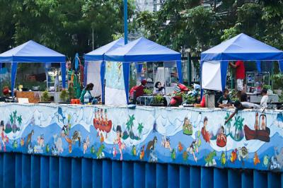 Sejumlah stand bazar ukm dengan berlatar mural cantik bertemakan kehidupan sungai di kawasan Kanal Banjir Barat, Jakarta Pusat, Senin (21/6/2021).