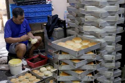 Pekerja menyelesaikan pembuatan roti skala rumahan di kawasan Bendungan Hilir, Jakarta, Senin (21/6/2021).