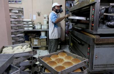 Pekerja menyelesaikan pembuatan roti skala rumahan di kawasan Bendungan Hilir, Jakarta, Senin (21/6/2021).